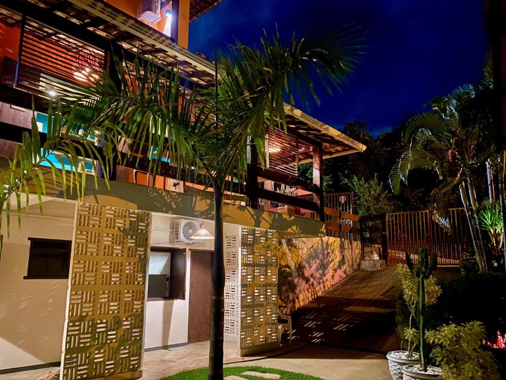 um edifício com uma palmeira em frente em Pousada Panorama Cipo em Santana do Riacho