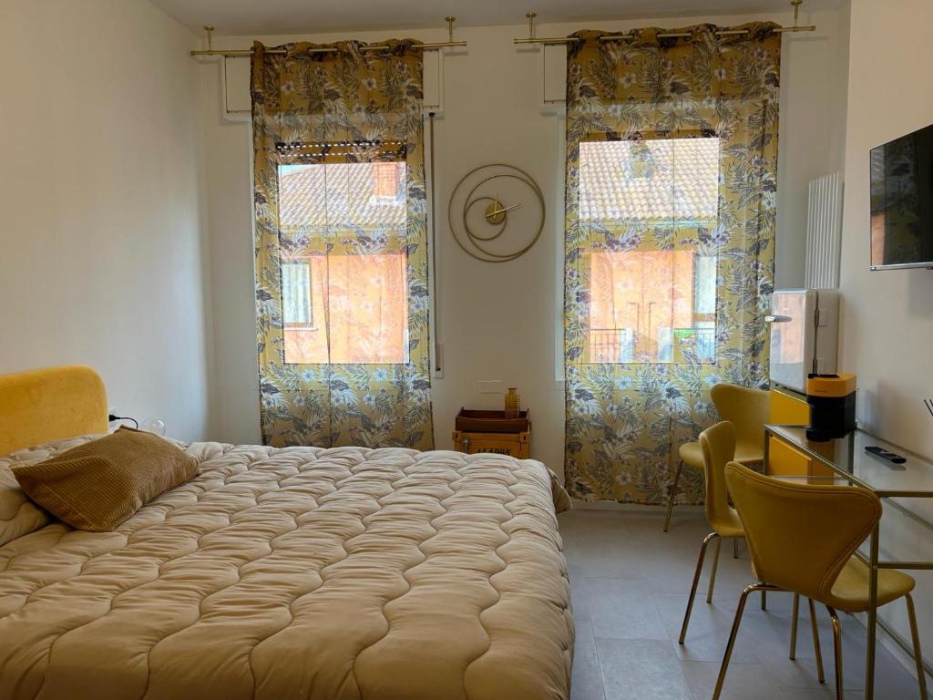 ein Schlafzimmer mit einem großen Bett und zwei Fenstern in der Unterkunft COMFORT ACCOMMODATION SUITE in Bergamo