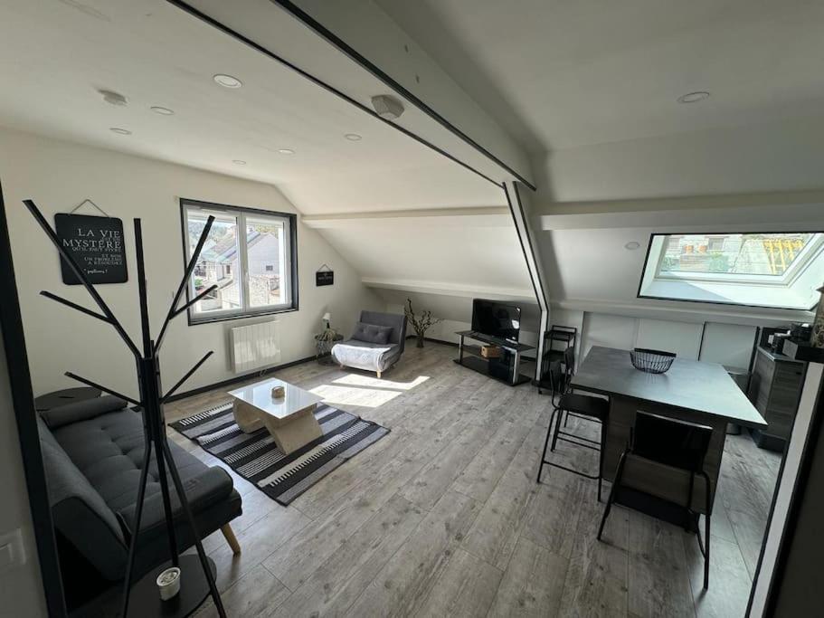 a living room with a couch and a table at ARconciergerie Logement cosy centre-ville in Maisse