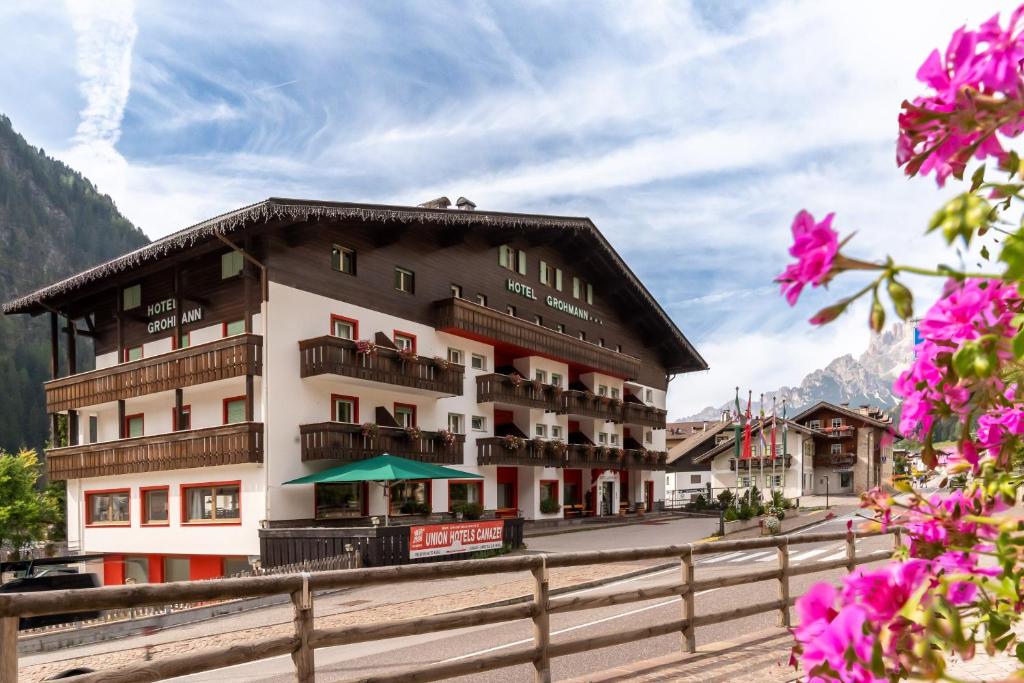 hotel w górach z różowymi kwiatami w obiekcie Hotel Grohmann w mieście Campitello di Fassa