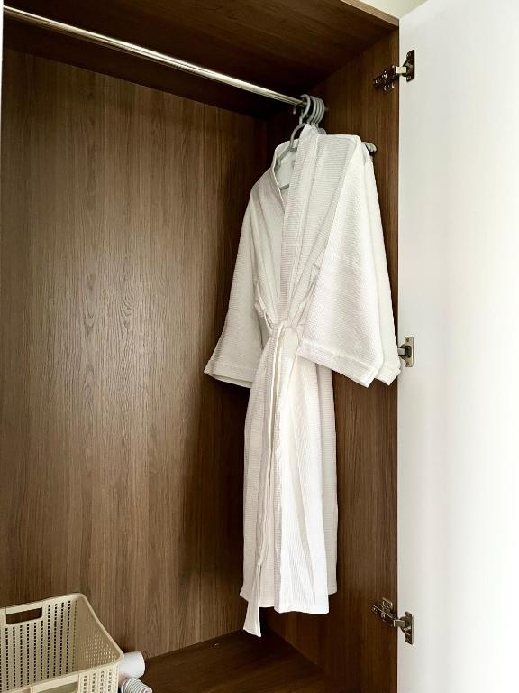 a white robe hanging on a closet door at SAFFRON Dalat in Da Lat