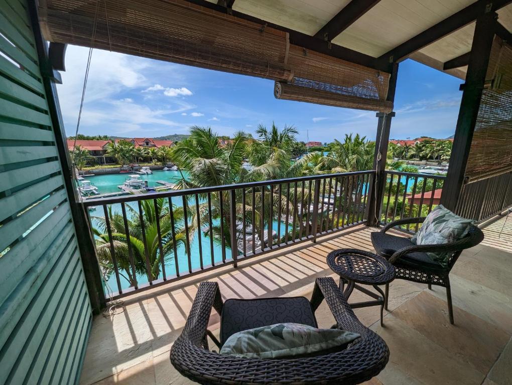 a balcony with a view of a pool and palm trees at Eden Island Apartment Citronelle in Eden Island