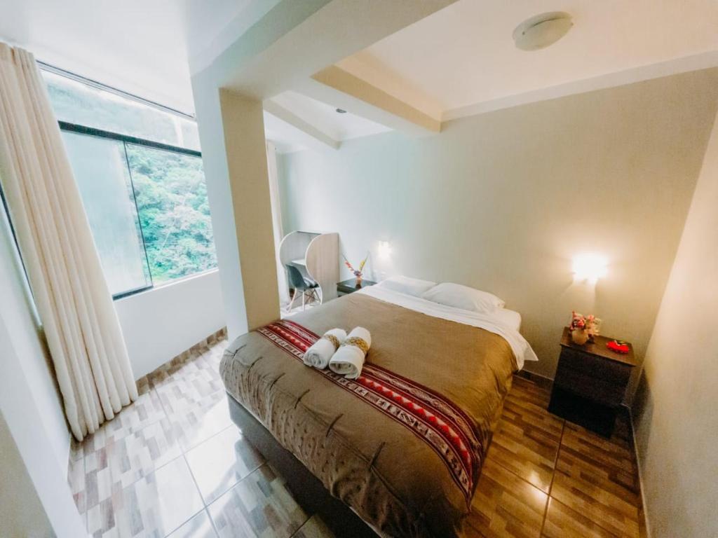 1 dormitorio con cama y ventana grande en RUMIQOLQA Machupicchu Hotel en Machu Picchu