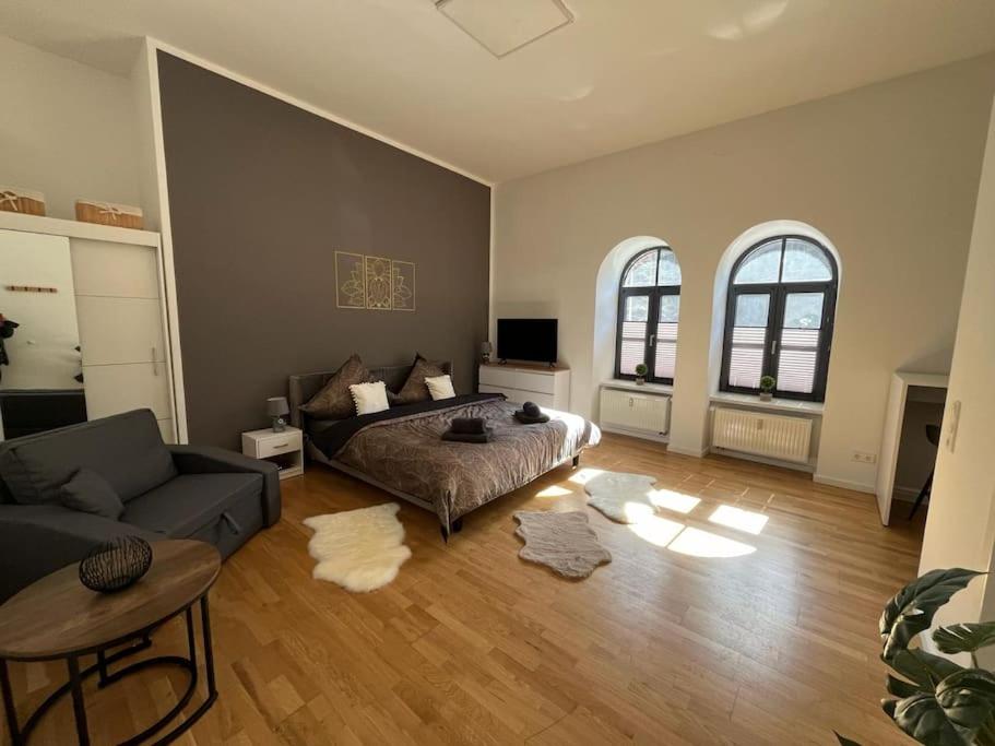 een slaapkamer met een bed, een bank en een tafel bij Loftstyle I WLAN I Stellplatz in Dresden