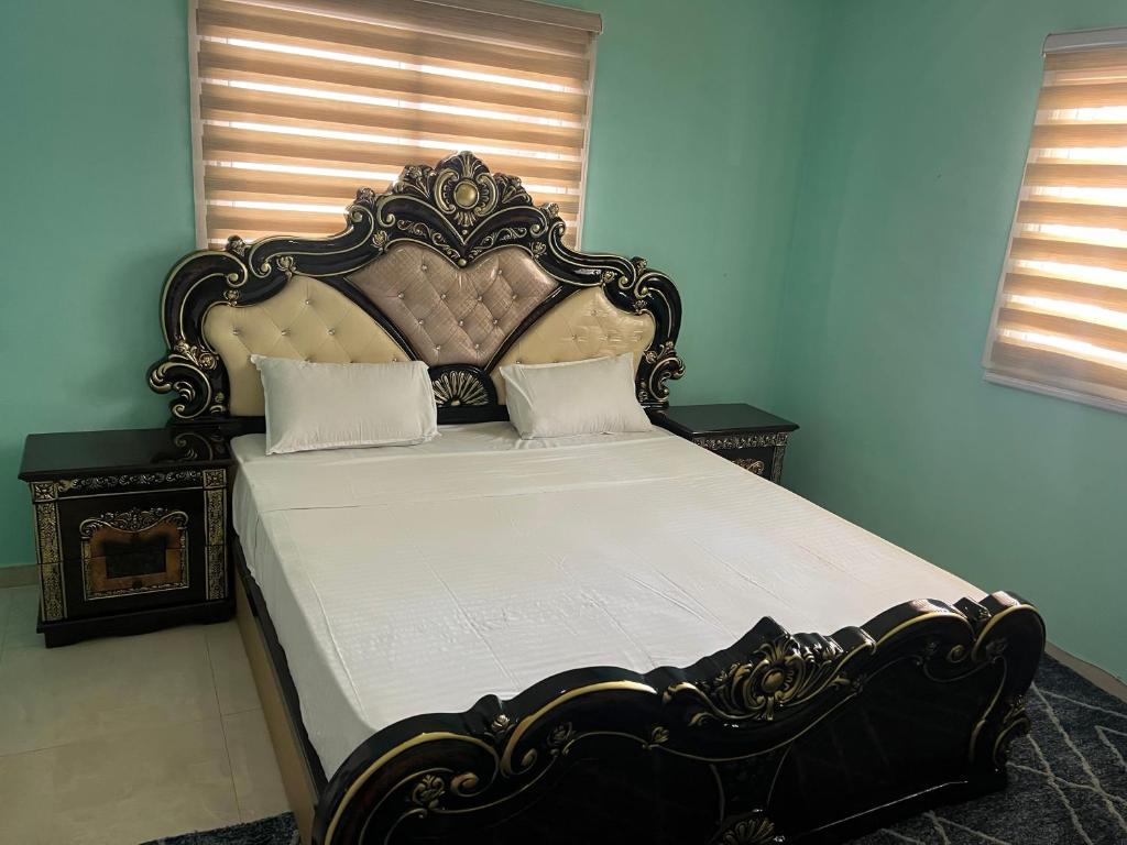 uma cama com uma cabeceira ornamentada num quarto em Chambre SDB simple avec accès piscine em Sali Poulang