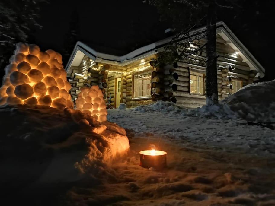 una vela encendida en la nieve frente a una casa en Villa Laattamaja - High quality genuine loghouse, en Ylläsjärvi