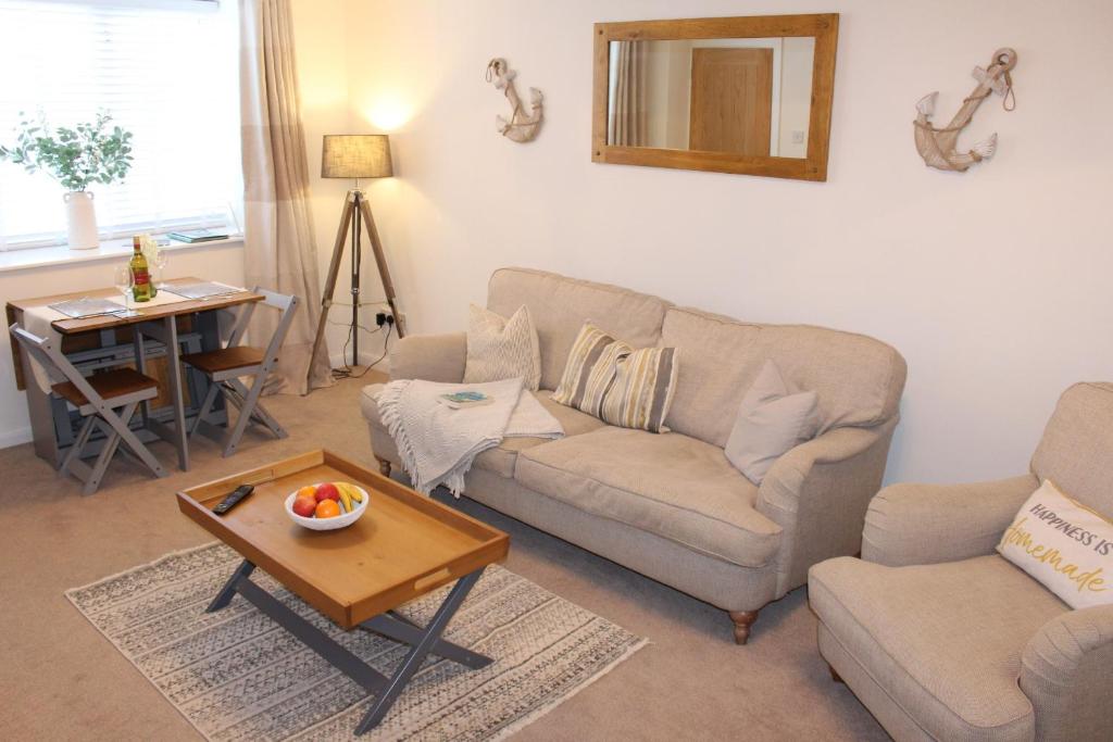 ein Wohnzimmer mit Sofa und Tisch in der Unterkunft Seaside Cottage 2 Bedroom - Bron-Y-Wendon Holiday Park in Llanddulas