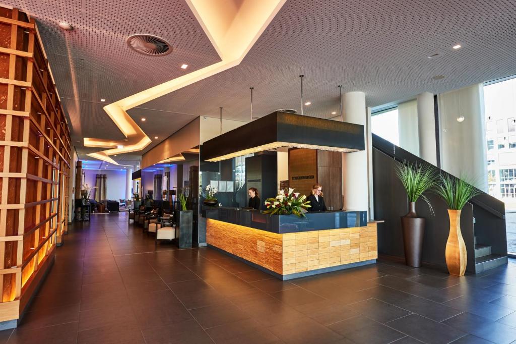 a lobby of a building with people sitting at a counter at Steigenberger Hotel Bremen in Bremen