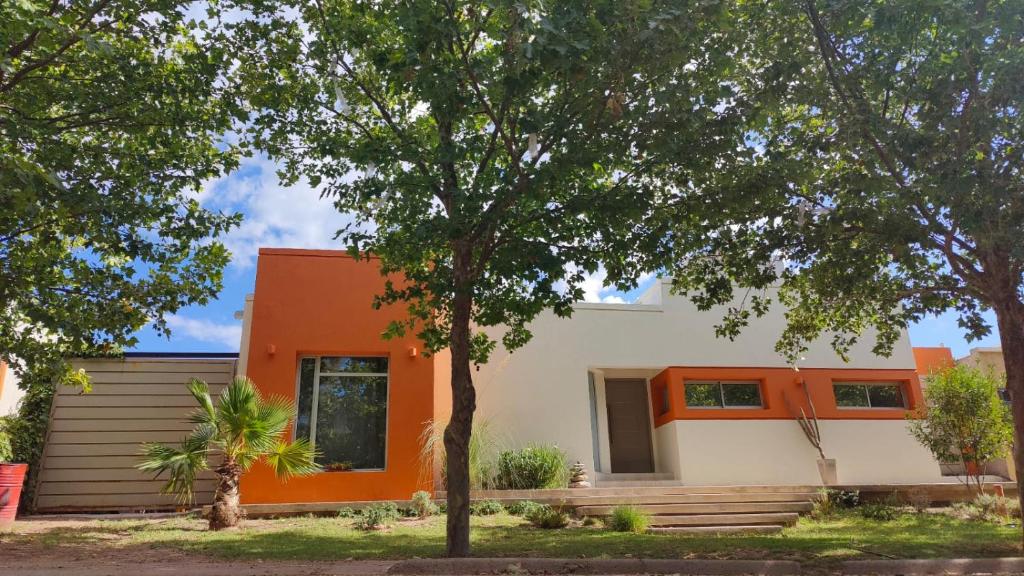 a house with an orange and white facade at Hermosa Casa Vistalba in Ciudad Lujan de Cuyo
