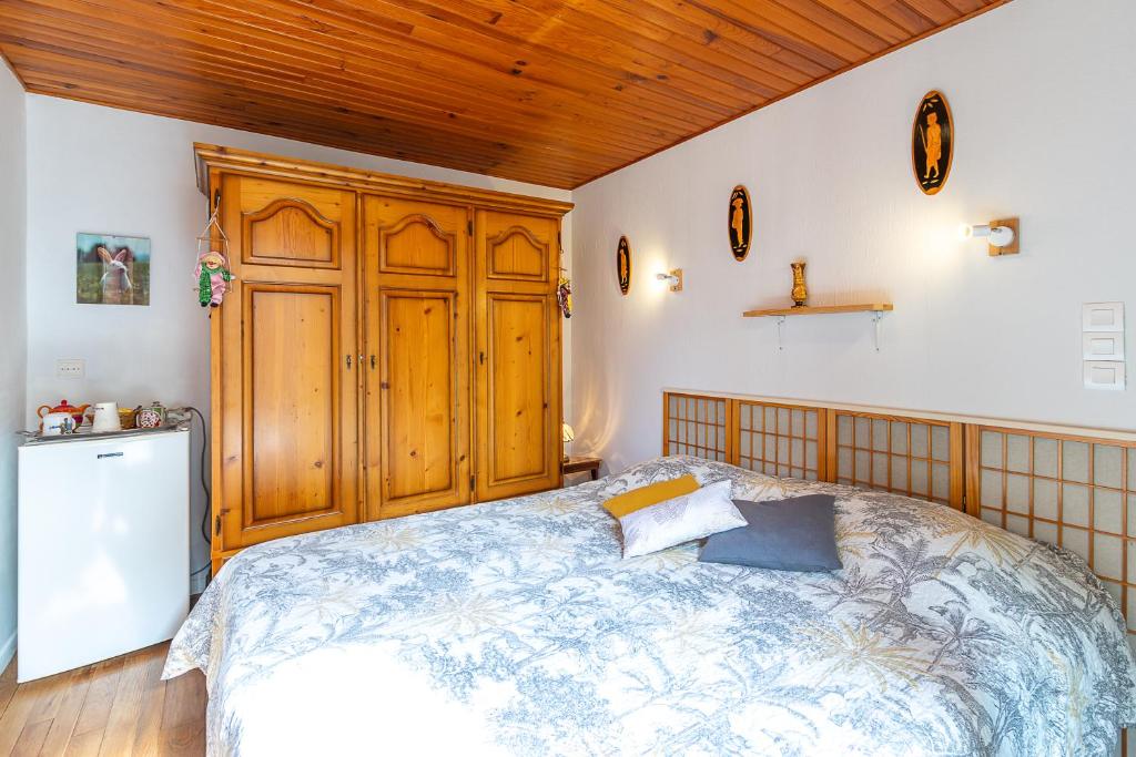 una camera con letto e armadio in legno di Chambre sous les mimosas 2kms plage a Saint-Jean-de-Monts