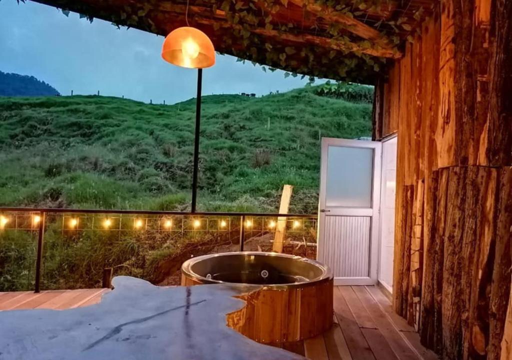 - une baignoire sur la terrasse avec vue sur la montagne dans l'établissement Hotel Cabañas y Chalets lujosos Mágica Luna, à Villamaría