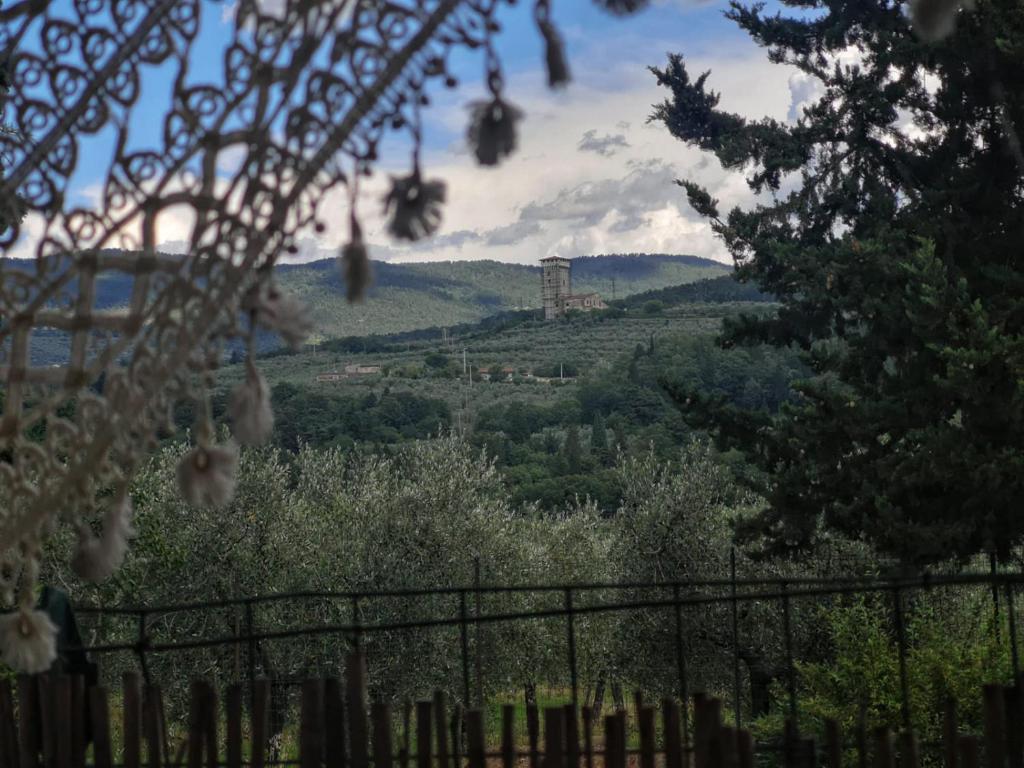 - une vue sur une colline avec un château au loin dans l'établissement La petite suite, à Calenzano