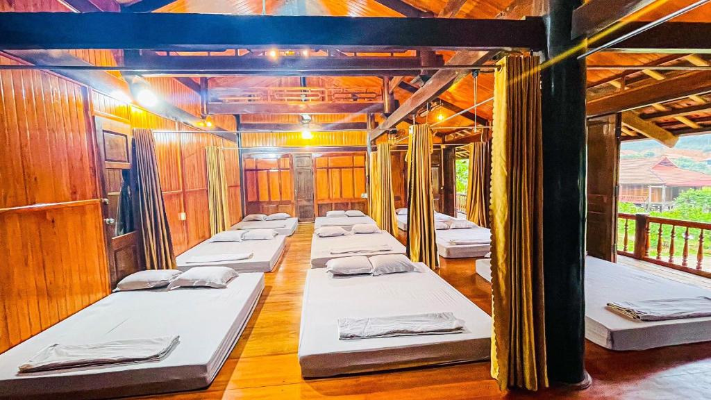 fila de camas en una habitación con paredes de madera en Homestay Yến Long, en Lạng Sơn