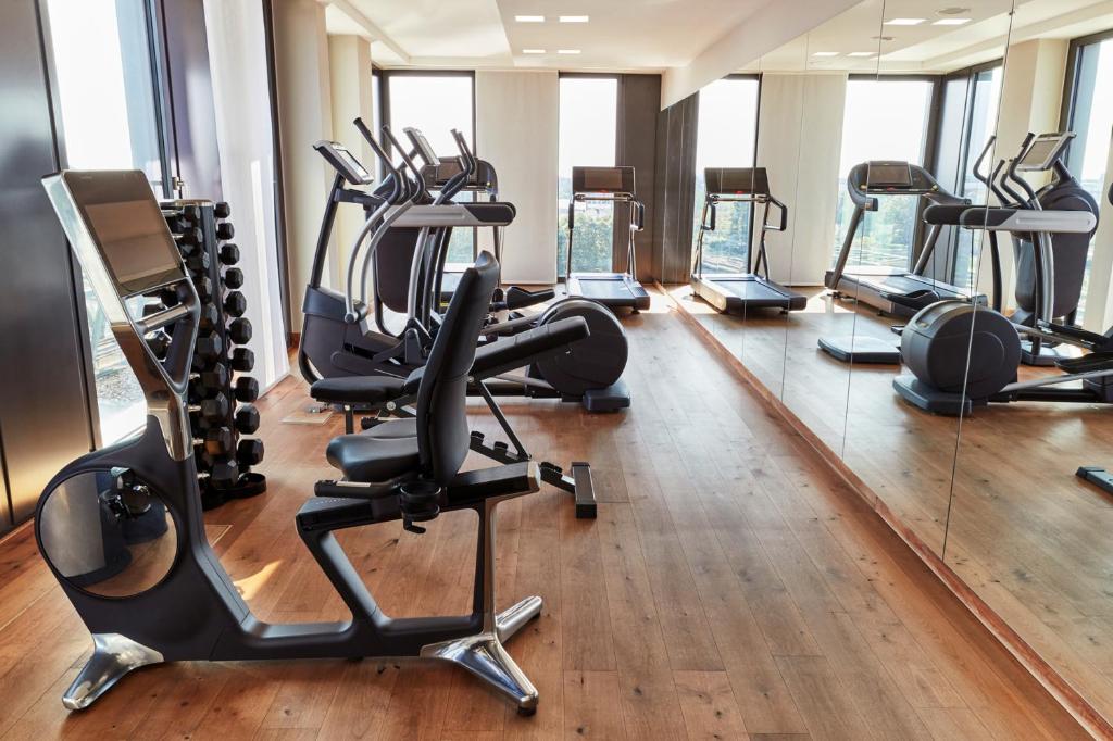 a gym with several treadmills and elliptical machines at Steigenberger Hotel Bremen in Bremen