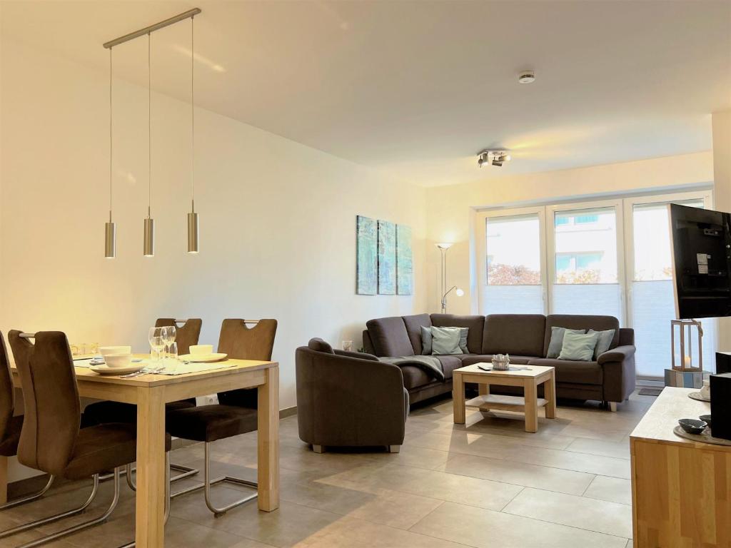 a living room with a couch and a table at Apartment Oase am Meer, Am Alten Deich 18 in Dangast