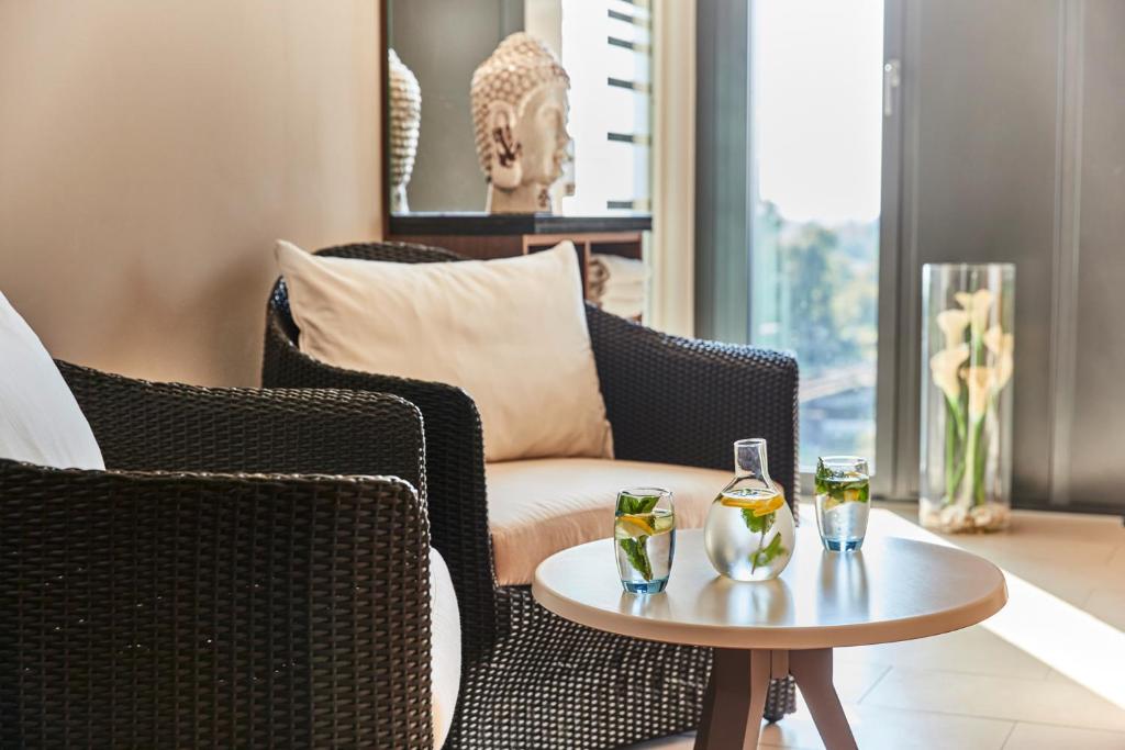 a living room with chairs and a table with drinks on it at Steigenberger Hotel Bremen in Bremen