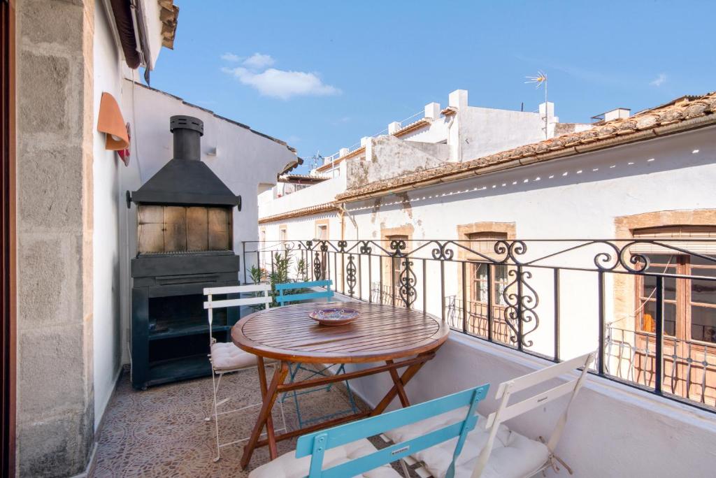 a small balcony with a wooden table and chairs at Somni in Jávea