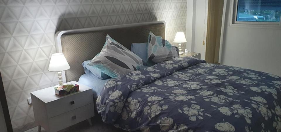 a bedroom with a bed with a blue comforter and pillows at LUX & VIP apartment at Berges du Lac 2 Tunis in La Goulette