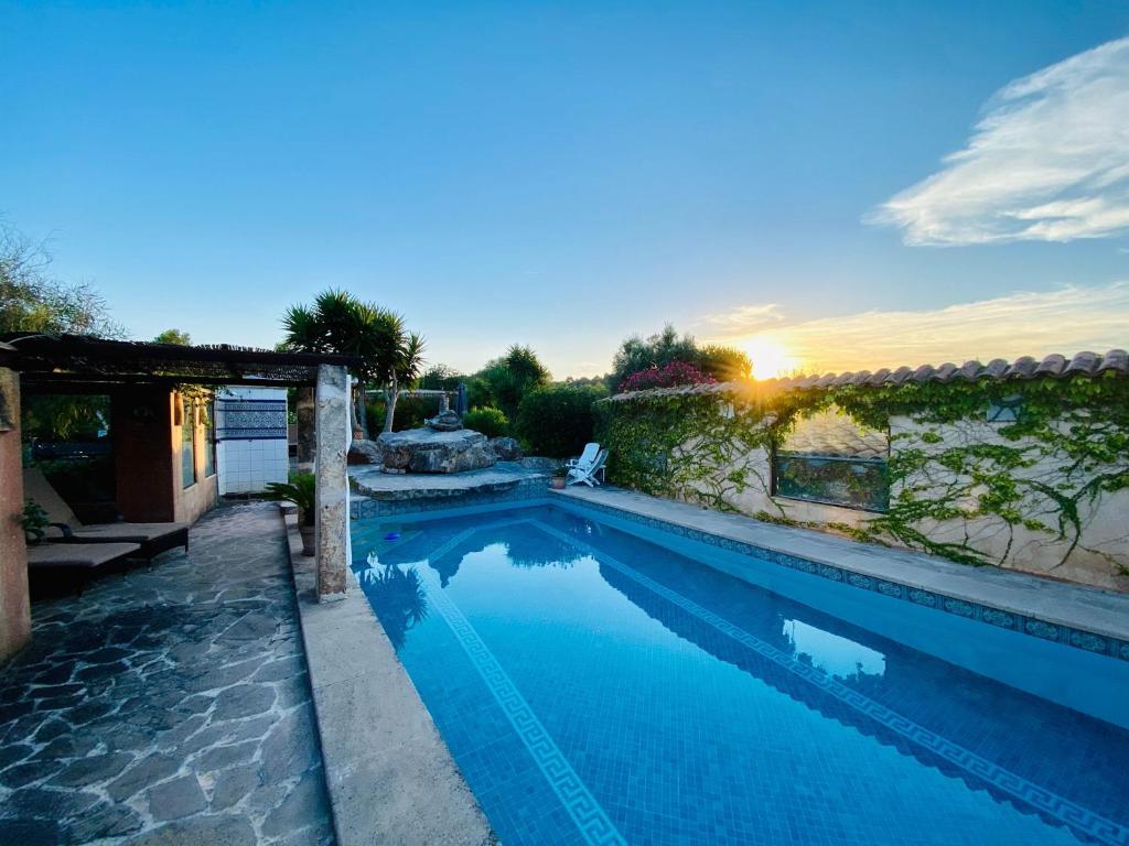 a swimming pool with a sunset in the background at FincaOase-Can-Negre-Son-Macia-App-Petit in Son Macia