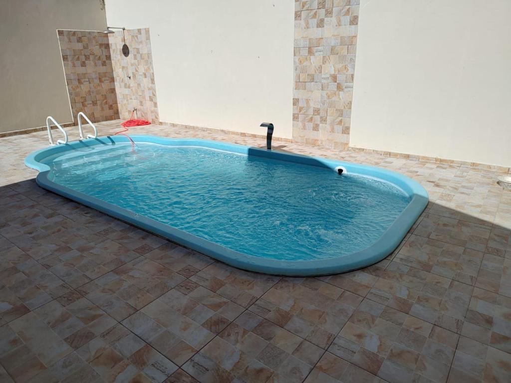 uma grande banheira azul num quarto com piso em azulejo em Casa de Temporada Isaura em Olímpia