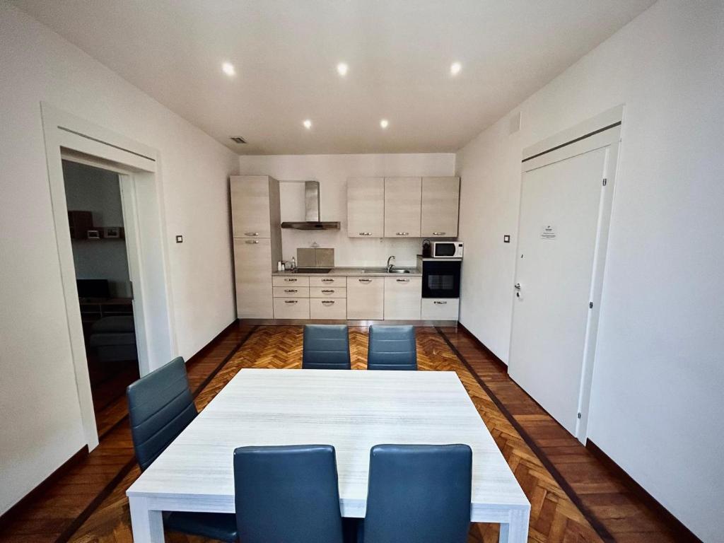 a kitchen with a white table and blue chairs at Centro Storico Suites in Ferrara