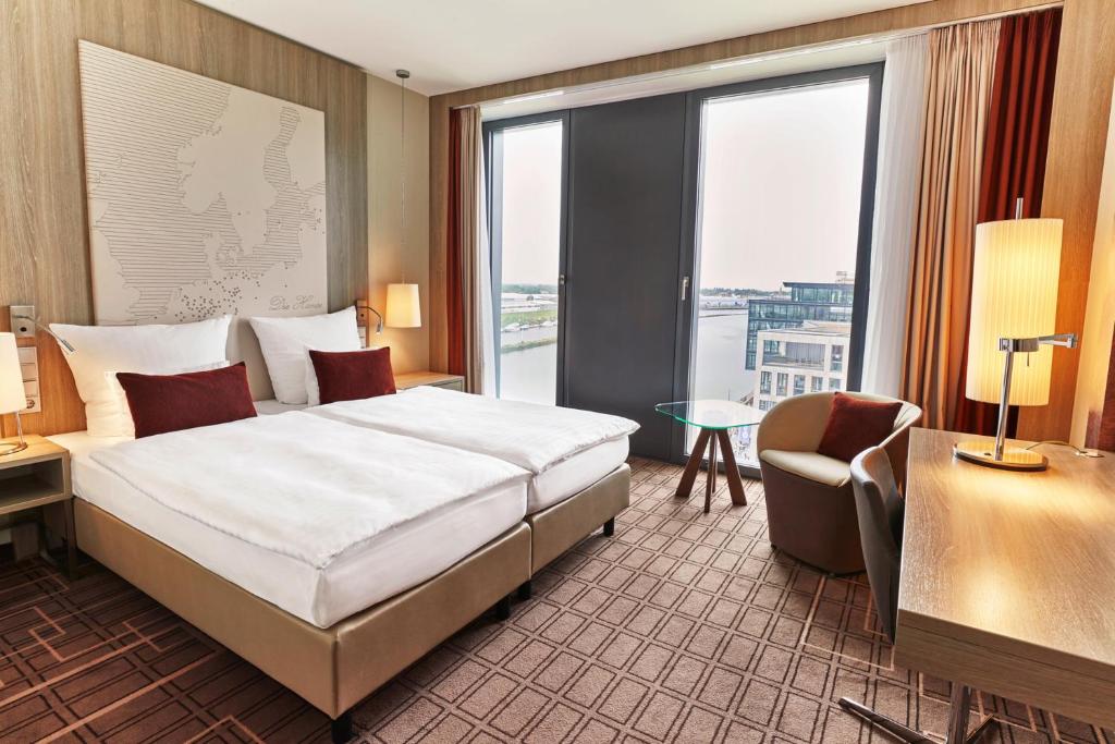 a hotel room with a bed and a large window at Steigenberger Hotel Bremen in Bremen