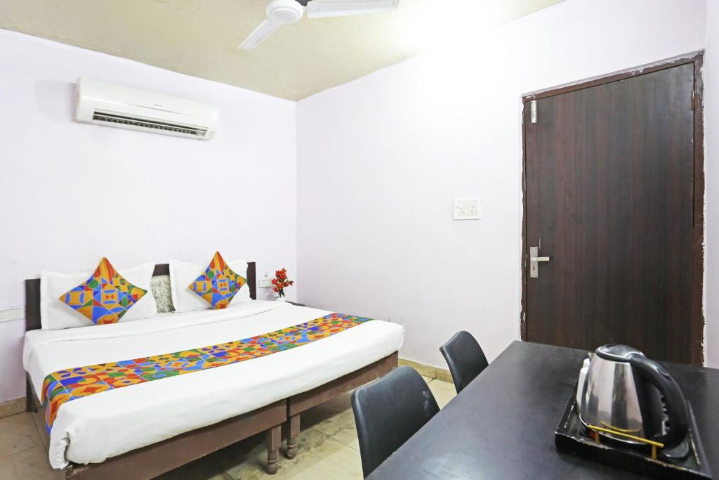 um quarto com uma cama e uma mesa com cadeiras em Twamev Punjabi Bagh em Nova Deli