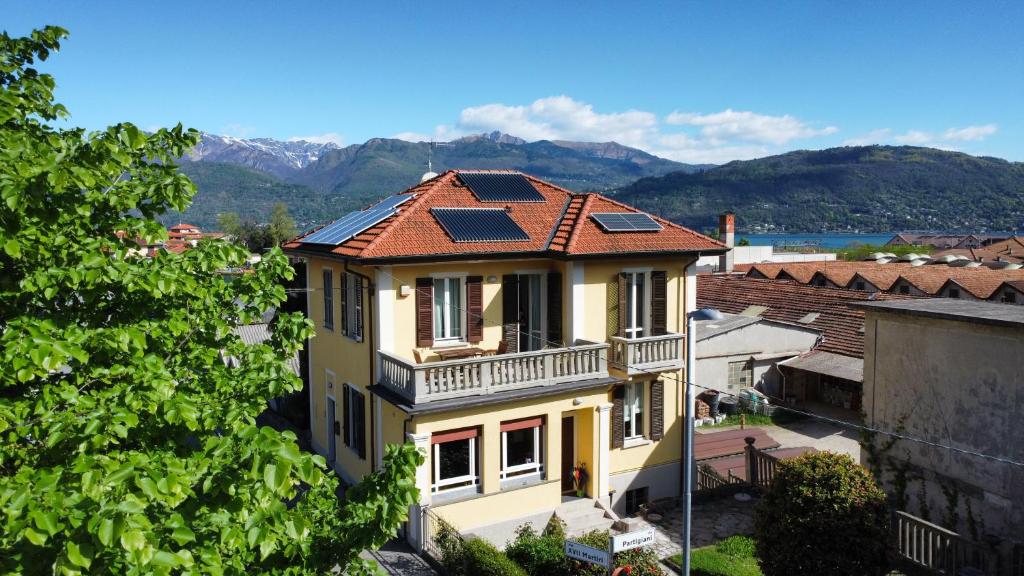 une maison jaune avec des panneaux solaires sur son toit dans l'établissement LA CASA GIALLA, à Baveno