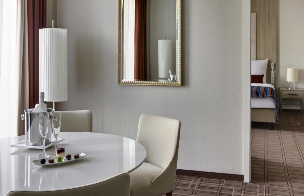 a dining room with a white table and chairs at Steigenberger Hotel Bremen in Bremen