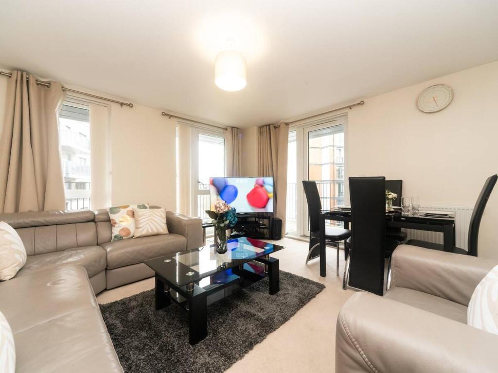 ein Wohnzimmer mit einem Sofa und einem Tisch mit einem Klavier in der Unterkunft Pass the Keys Modern 2 bedroom and 2 Bath Apartment in London in Edgware