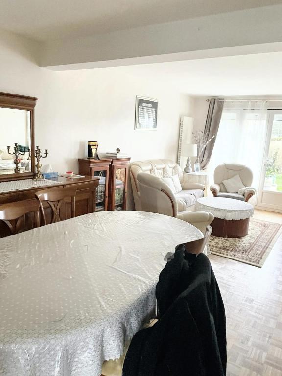 a living room with a table and a couch at Villa de 4 chambres avec jardin clos et wifi a Elancourt in Élancourt