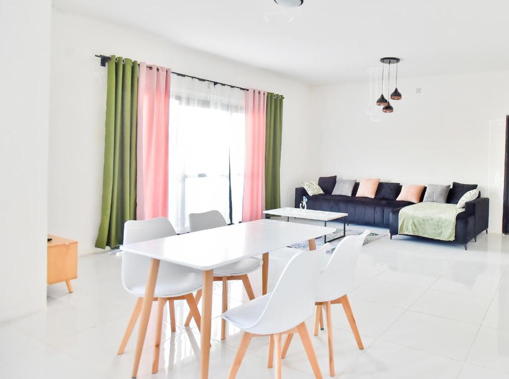 a living room with a table and chairs and a couch at Appartement à Ivandry in Antananarivo
