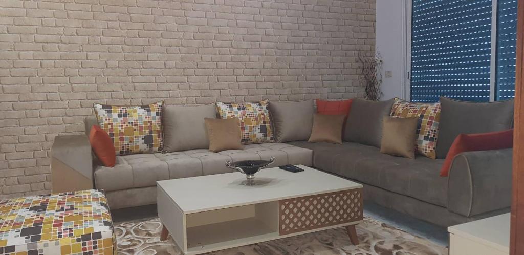 a living room with a couch and a coffee table at Charming and Cosy Apartment close to TUNISIA MALL Lac2 Tunis in Tunis