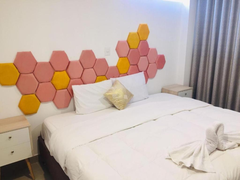 1 dormitorio con cama blanca y cabecero hexagonal en HOTEL CUSCO PERU, en Cusco