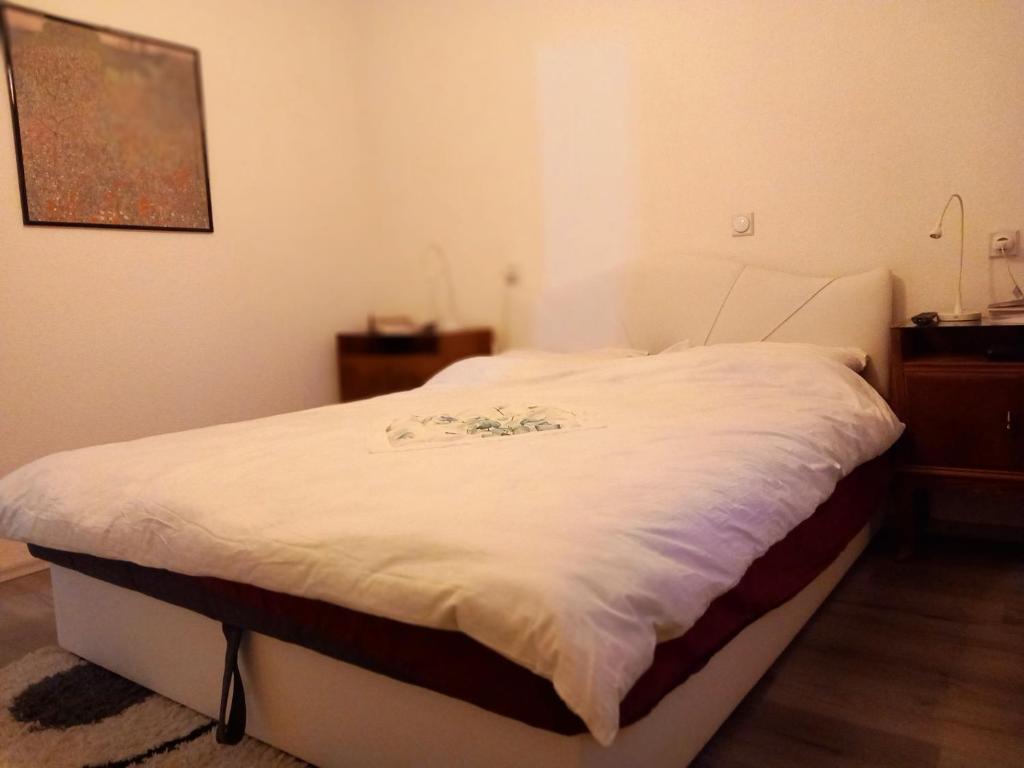 un letto bianco in una stanza con una foto sul muro di Villa Marinov a Ohrid