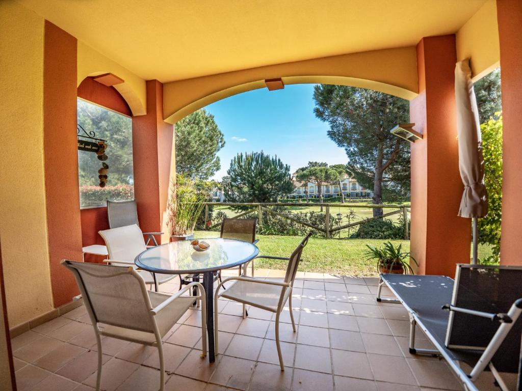 a patio with a table and chairs and a view at AMA Residences Andalucia in Islantilla