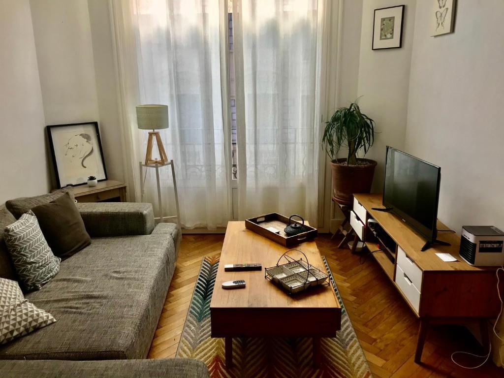 un salon avec un canapé et une table basse dans l'établissement Le beau Niçois, à Nice