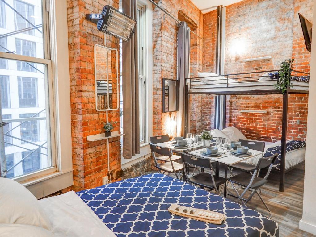 a room with a dining table and a brick wall at Empire Broadway Retreats in New York