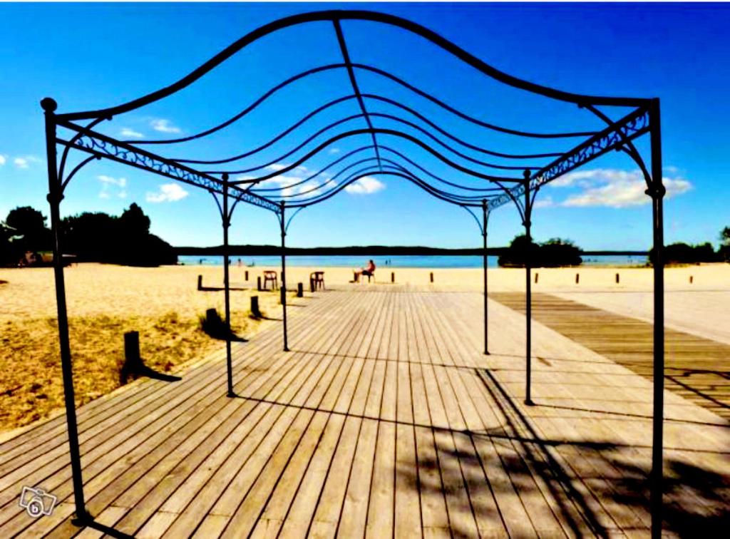 acovered boardwalk on a beach with a blue canopy at Bungalows climatisés en 3 ou 4ch - jusqu'à 18 voyageurs - mh732 3ch ou mh828 4ch Biscarrosse Lake-proche océan in Gastes
