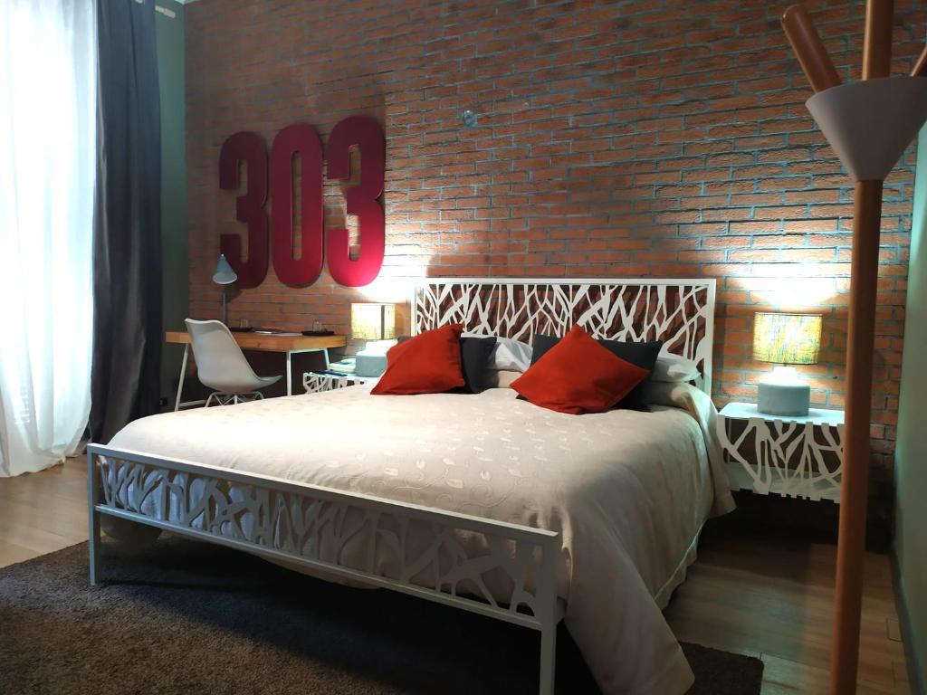 1 dormitorio con cama y pared de ladrillo en Albergo Mango, en Francavilla in Sinni