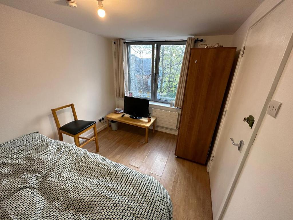 1 dormitorio con 1 cama y escritorio con ordenador en Newbury, en Londres