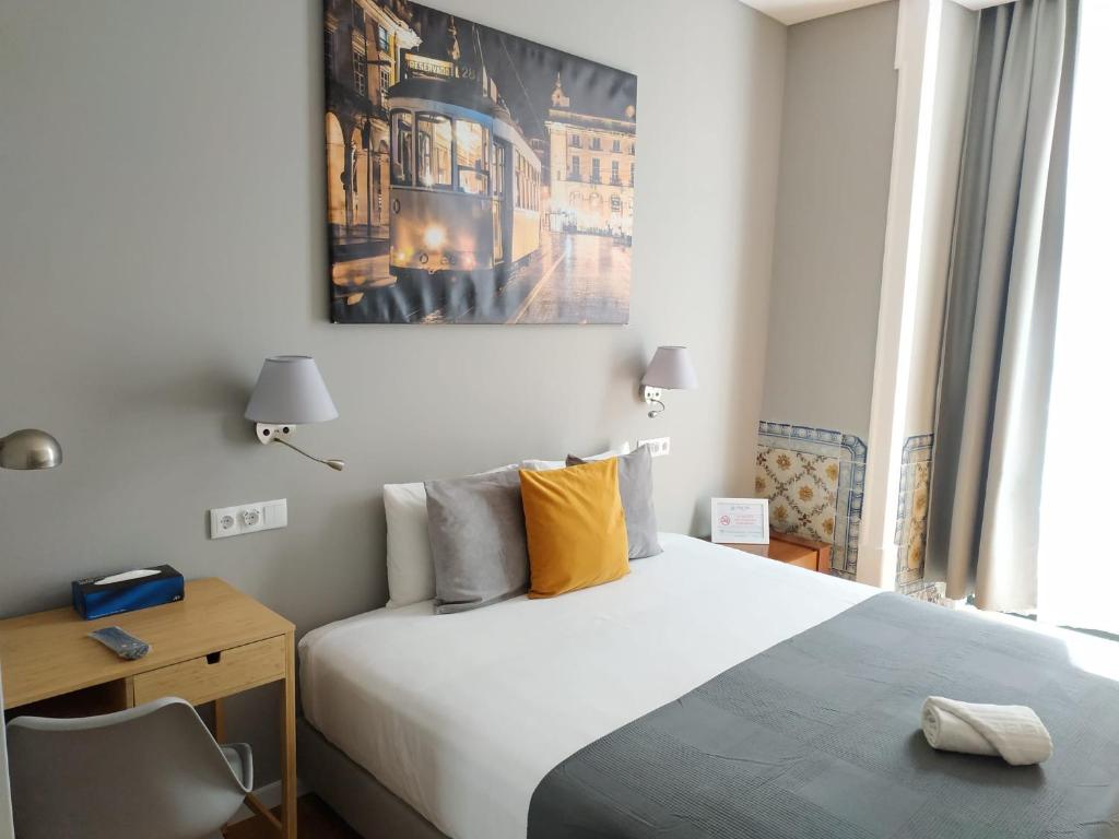 リスボンにあるGreat Stay Fanqueiros 5 & 2のベッドルーム1室(ベッド1台、デスク付)、壁に絵画が備わります。
