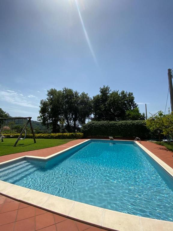 a swimming pool in a yard with a playground at B&B LA ROSA in Salerno