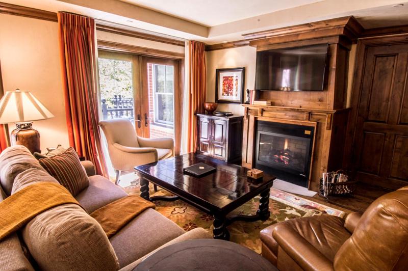 sala de estar con sofá y chimenea con TV en Aspen Mountain Residences, Luxury 2 BR Residence 15,1 Block from Ski Lifts en Aspen