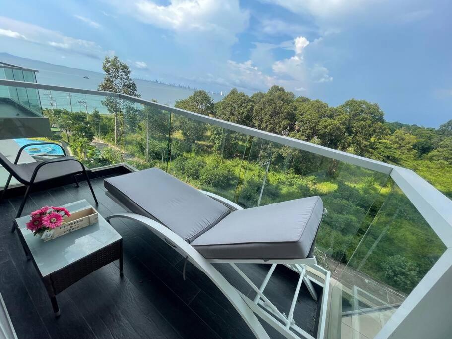 邦萨雷Delmare Beachfront Bangsaray的建筑物上的阳台上有两把椅子和一张桌子