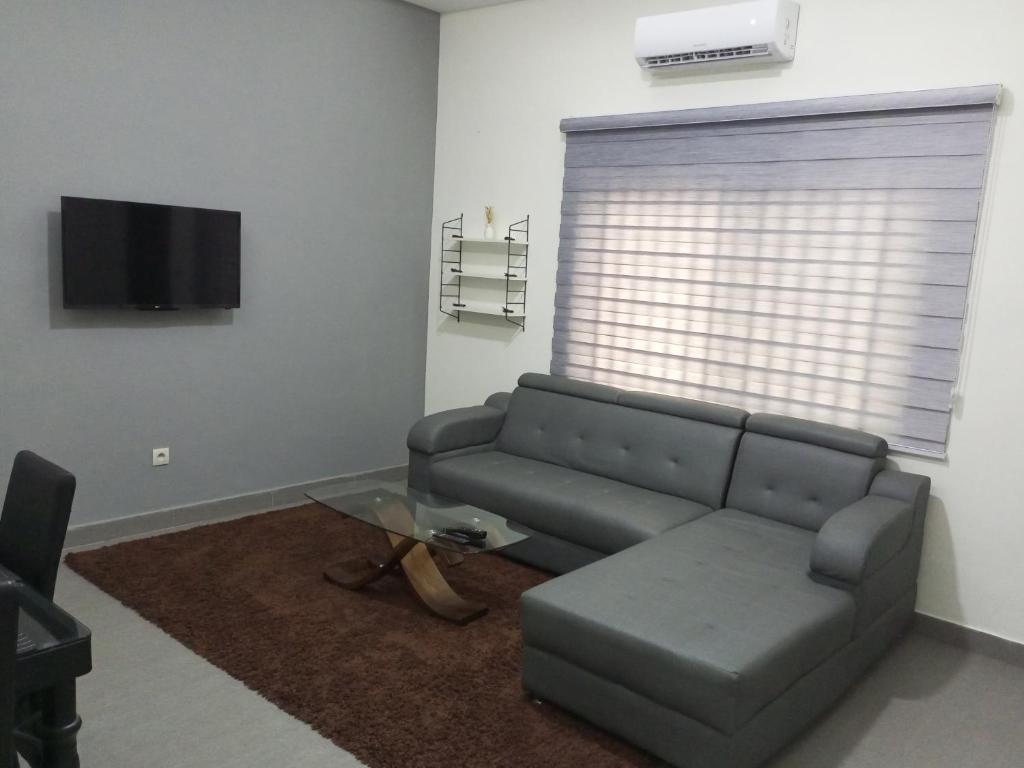 a living room with a couch and a tv at RG Résidences in Cotonou