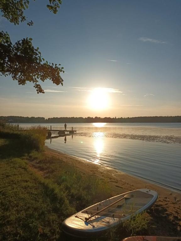 un bateau assis sur la rive d'un lac dans l'établissement Gustiņi, à Baltezers