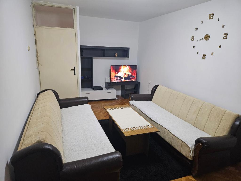 a living room with a couch and a tv at Apartman NINA in Kuršumlija