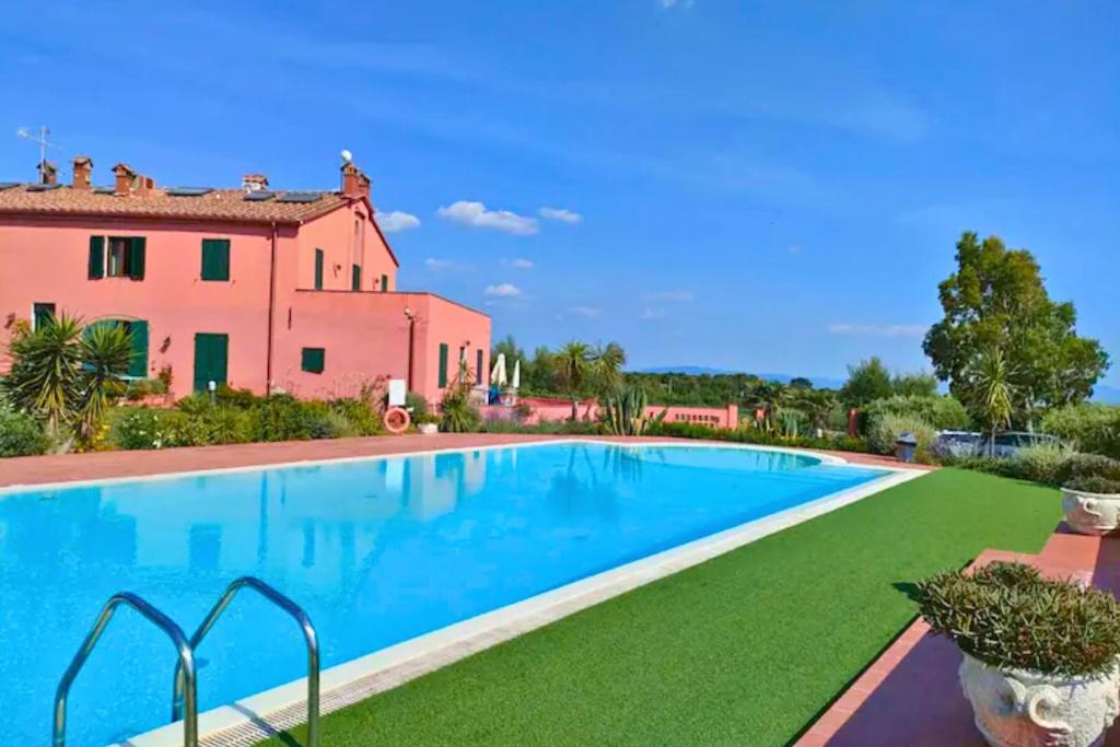 una imagen de una piscina frente a una casa en Green View Apartment with pool, en Castiglioncello