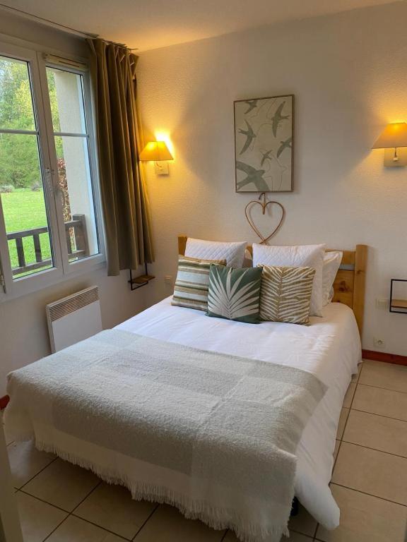 a bedroom with a large white bed with pillows at Charm Burgundy in Levernois